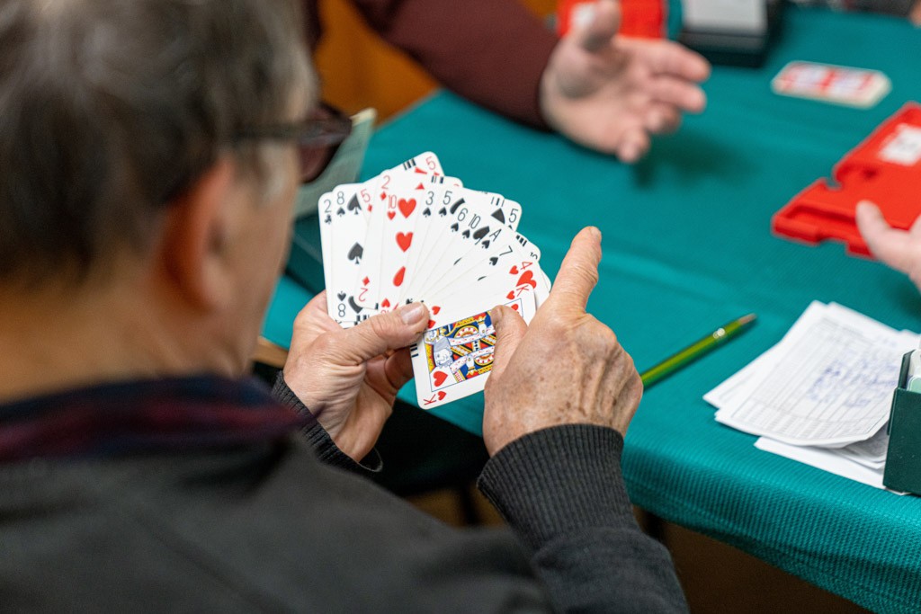osoby przy stoliku grają w karty